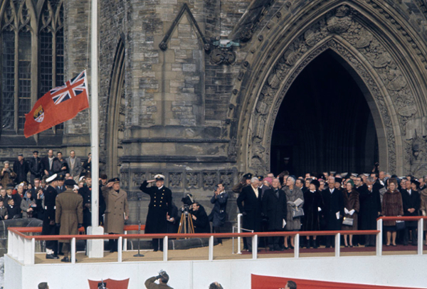 Raising of the maple leaf flag of Canada for the first time, at 12 noon, in front of the Peace Tower