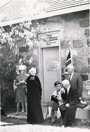 Gertrude Girvin (standing center) with Mrs. W. P. Bate (seated on her right), J. C. Hunter (also seated on her right), and F. M. Kusch (standing behind), who are all former pupils of the school. They were gathered for the official opening of the Little Stone Schoolhouse on the USask campus in 1967. Saskatoon Public Library PH-2018-60-10